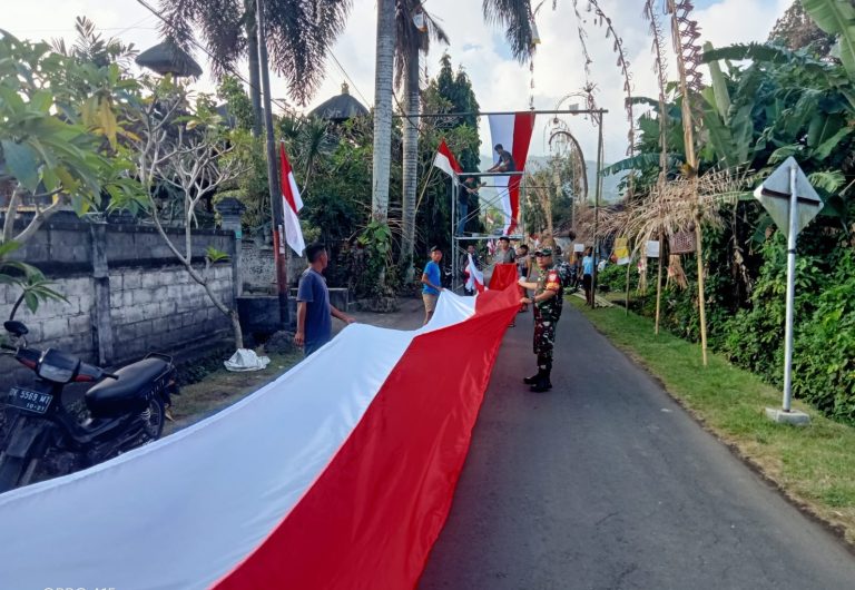 2. Babinsa Pikat Bersama Warga Bentangkan Bendera Sepanjang Ratusan Meter
